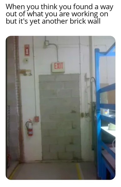 Exit sign on a wall over a bricked up doorway.

Caption: When you think you found a way out of what you are working on but it's yet another brick wall