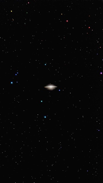 A view of Sombrero Galaxy by a star-filled black background. The several small stars in various colors are visible.

Widok galaktyki Sombrero na czarnym tle wypełnionym gwiazdami. Kilka małych gwiazd w różnych kolorach jest widocznych.