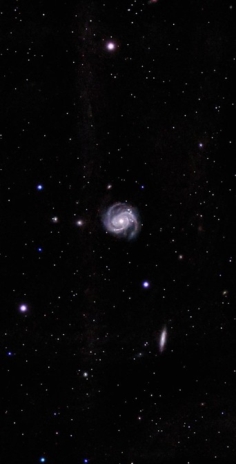 The image features a spiral galaxy surrounded by a field of stars against a dark background.

Obraz przedstawia galaktykę spiralną otoczoną polem gwiazd na ciemnym tle.