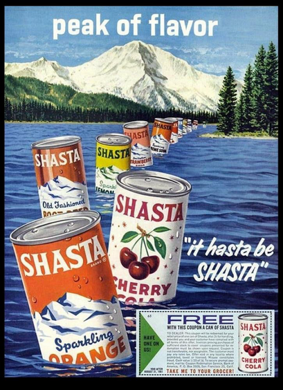 Cans of Shasta soda March on top of water in a mountain view with a lake. The lake is surrounded by conifers.