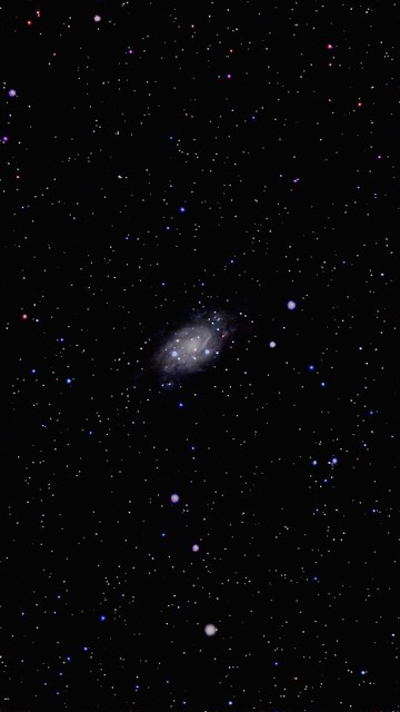 The image features a view of space filled with numerous stars against a black background, showcasing a spiral galaxy in the center along with various colored celestial bodies surrounding it.

Obraz przedstawia widok przestrzeni wypełnionej licznymi gwiazdami na czarnym tle, pokazujący galaktykę spiralną w centrum wraz z otaczającymi ją różnymi kolorowymi ciałami niebieskimi.