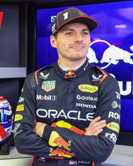 Max, smiling with his arms crossed in the garage