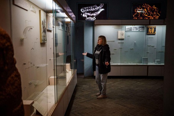 The interim director of the Kherson Regional Museum stands in front of empty display cases looted by Russian forces, in Kherson, Ukraine
