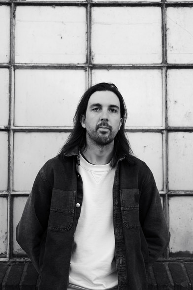 Portrait of Kaj standing in front of a wall, facing the camera