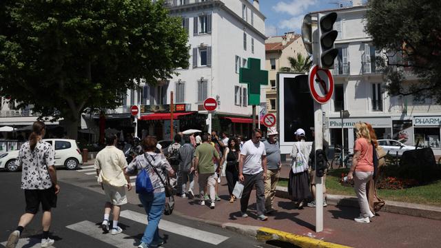 Pedestrians in Cannes cross a street without working traffic lights due to a power outage on 24 May 2025. | © Sameer Al-Doumy, AFP