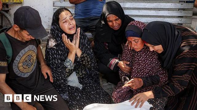 Palestinians mourn a person killed as they waited for a convoy of aid lorries on the coastal road north-west of Gaza City, at al-Shifa hospital, northern Gaza (14 June 2025)