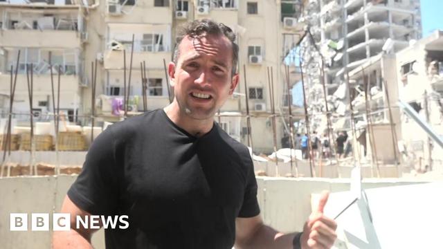 Hugo Bachega in front of a damaged building in Israel's Bat Yam