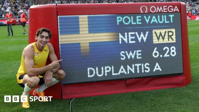 Armand Duplantis points at a scoreboard showing his world record