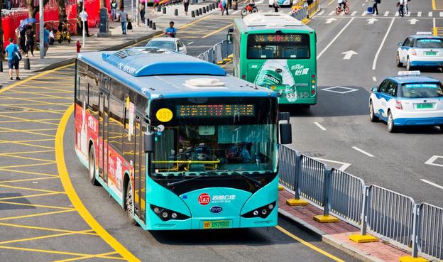An electric bus drives down a street.