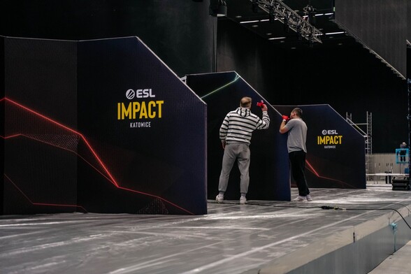 dwóch pracowników pracujących przy elementach sceny turnieju kobiecego CS-a ESL Impact