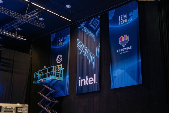 Pionowe bannery z logami Intela, ESL i Katowic na niebieskim tle, wiszące pod sufitem Międzynarodowego Centrum Kongresowego w Katowicach