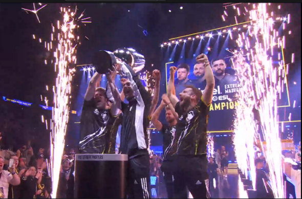 kadr z transmisji, zespół G2 Esports w triumfalnym geście podnosi trofeum IEM Cologne, wokół nich wybuchają fajerwerki, w tle widać telebimy na scenie z ich podobiznami