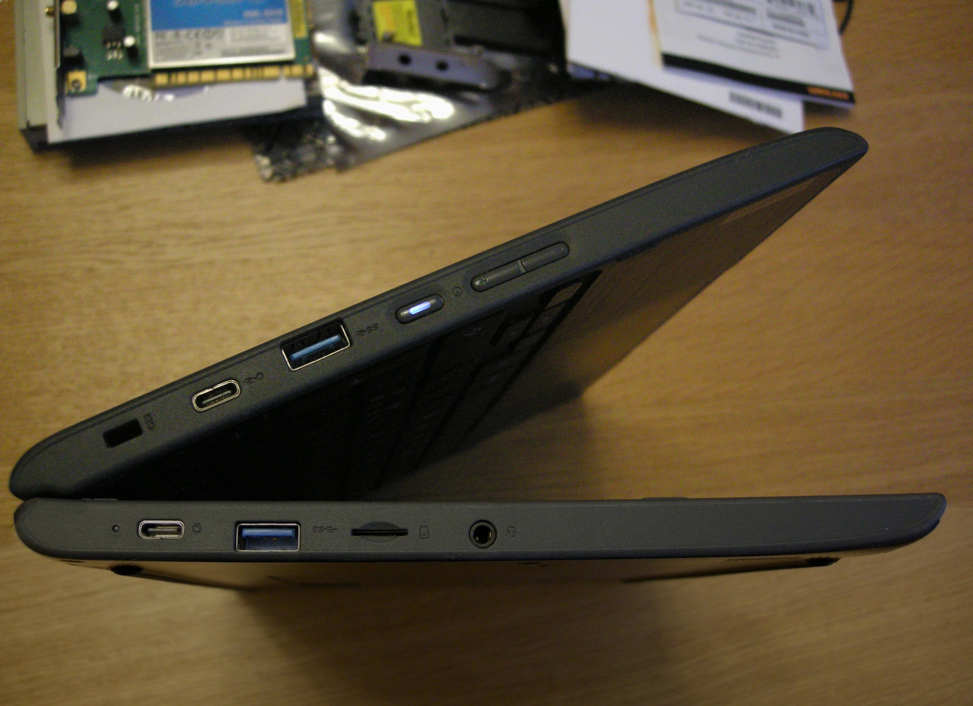 the chromebook on its side. both halves have holes out (two USB 3s, two USB-Cs, one of which charge-capable, one micro-SD card, one kensington lock, and volume up/down and power buttons), implying both halves are the keyboard half