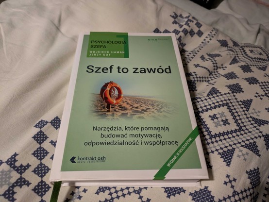 Zdjęcie książki "Szef to zawód" autorstwa Wojciecha Hamana oraz Jerzego Guta. Okładka jest zielona, ma zdjęcie koła ratunkowego na plaży na środku.