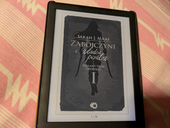 Okładka e-booka "Szklany Tron, Zabójczyni i Władca Piratów" autorstwa Sarah J. Maas. Widoczna jest duża rzymska cyfra jeden, gdyż jest to pierwsze opowiadanie ze zbioru opowiadań "Zabójczyni". Ten konkretny e-book ma 76 stron.