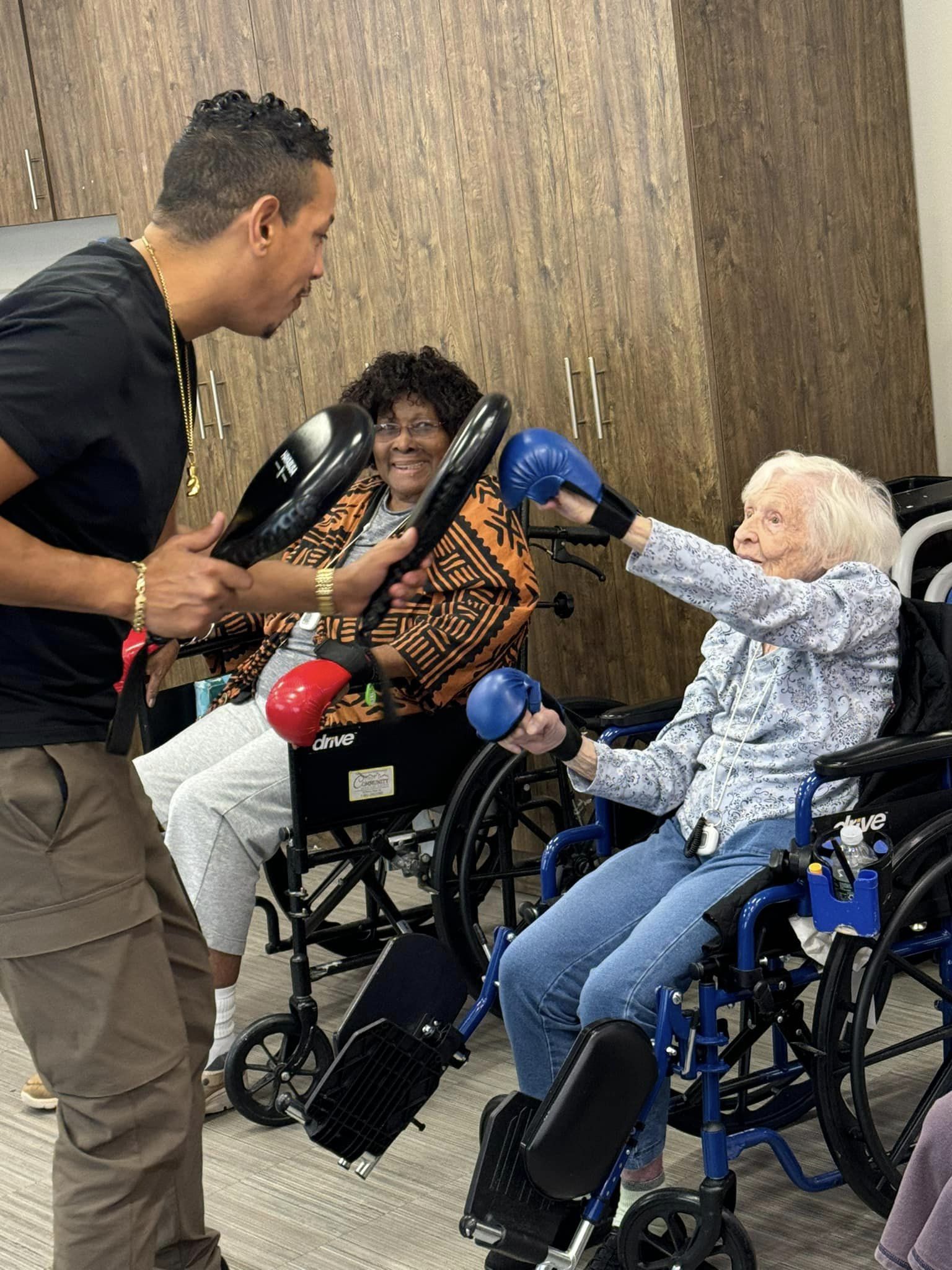 A woman in a wheelchair reaching for a boxing glove pad to hit